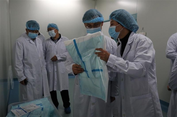 图为云南省药监局党组书记、局长刘本军(右二)检查该企业生产的医用一次性防护服。(云南省药监局供图) 图为云南省药监局党组书记、局长刘本军(右二)检查该企业生产的医用一次性防护服。(云南省药监局供图)