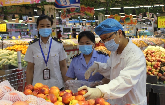 图为该局执法人员在一商场抽取食品样品送检。