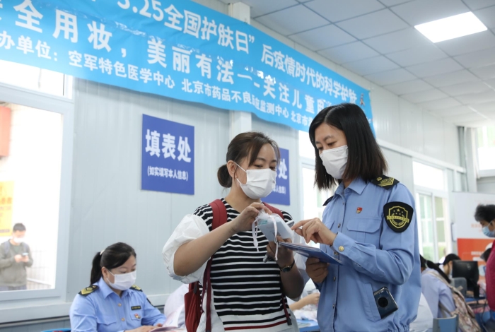 图 海淀区市场监管局监管人员在中国人民解放军空军特色医学中心为消费者讲解化妆品安全事项。