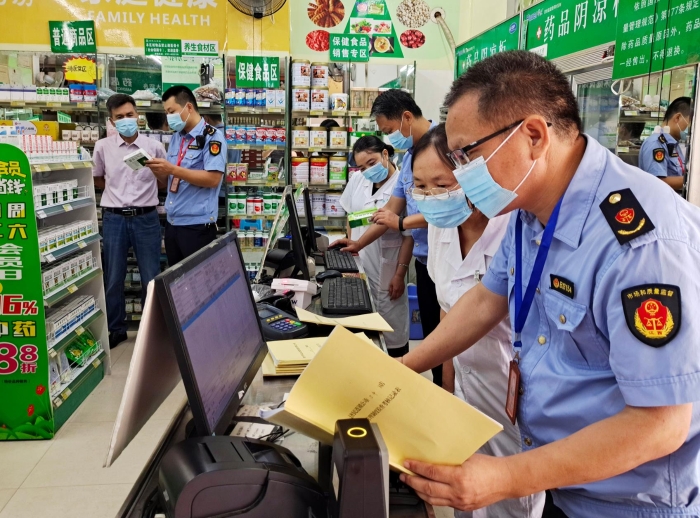 图为8月9日该局执法人员正在一药店开展执法检查。