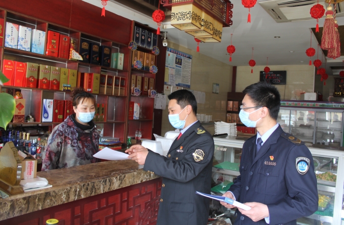 图为执法人员在一餐饮店进行检查和现场指导。