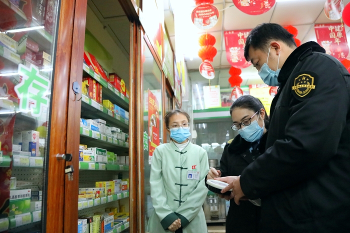 图为1月19日执法人员在一家药店检查。（何正君 摄）