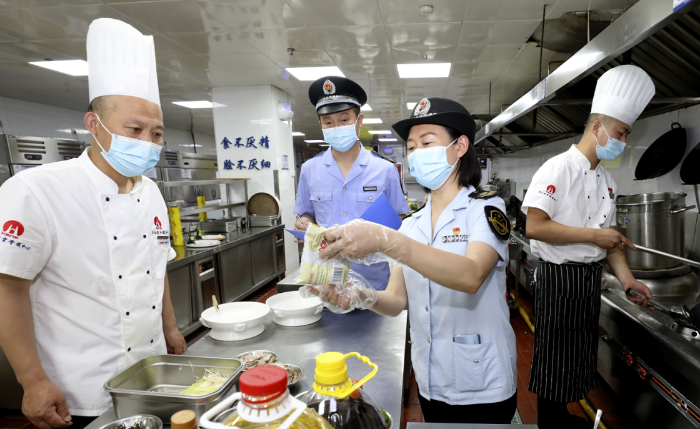 图为淮北市市场监管局执法人员在一家学校食堂检查食品加工环境。