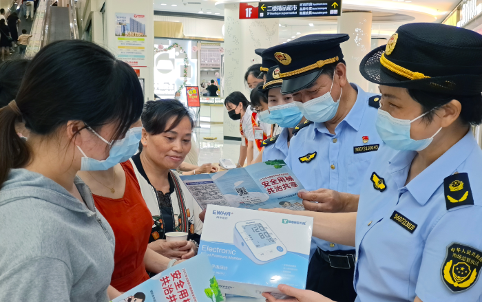 图为7月19日，于都县市场监管局工作人员在一家商场为群众讲解医疗器械安全知识。