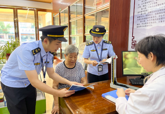 图为该局工作人员在一家药店内开展民生药事服务指导工作。