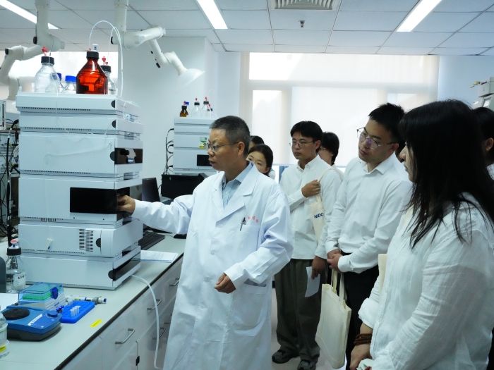 图为化药所工作人员演示自动化柱前衍生HPLC法测定氨基酸含量科普实验。